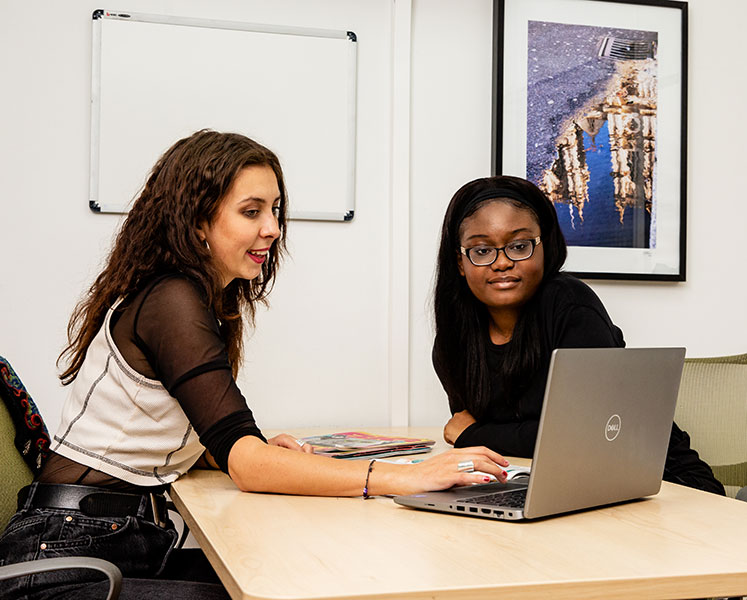 Two women looking at laptop in an office